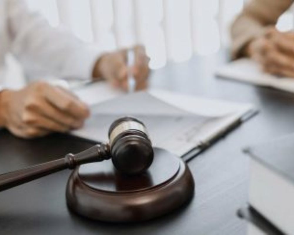 Mazo de juez sobre una mesa con documentos legales, simbolizando la defensa penal y el asesoramiento jurídico estratégico.