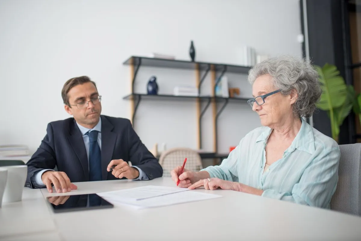 Elderly person accompanied by a relative while reviewing documents about support measures